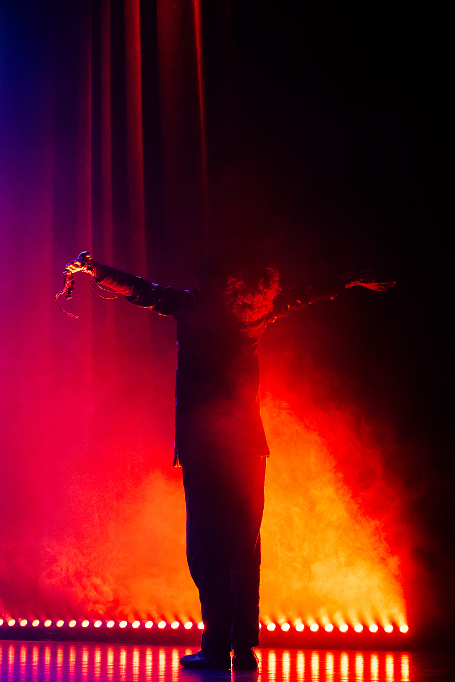 One of the members of The Cosmic Tones Research Trio on stage at Le Guess Who?, photographed from behind with arms outstretched
